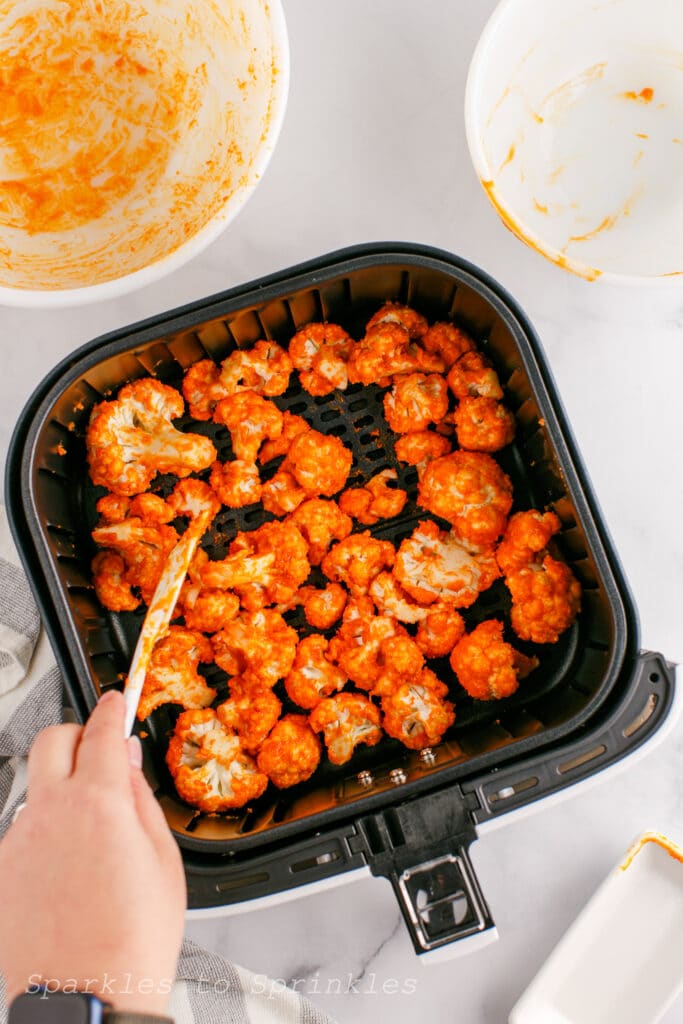 Heat up your Air Fryer to 350 degrees and place half of the cauliflower into the basket and bake for 10-12 minutes.